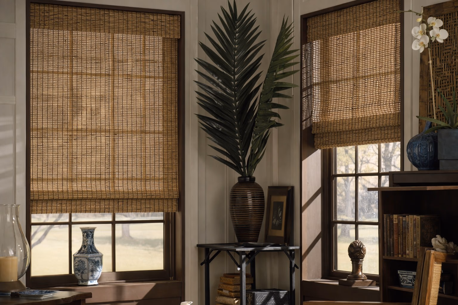 Hunter Douglas Provenance Woven Wood Shades in natural bamboo weave on windows of a traditional home study with dark wood furniture, installed by Bay Blinds
